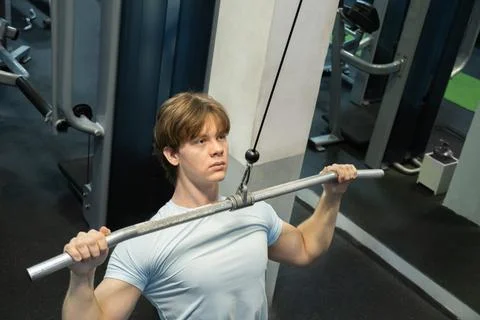 Pulling man cable machine exercise. Workout Routine With Personal Trainer Stock Photos