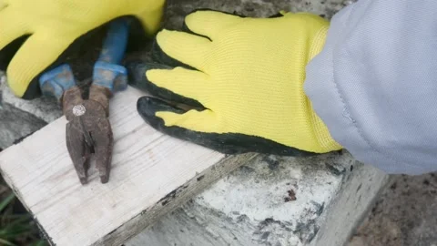 Pulling a nail out of a board with pliers, on a ladder Vídeos de archivo 228709336