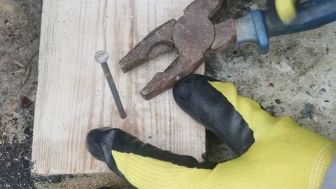 Pulling a nail out of a board with pliers, close-up Vídeo Stock 228709358