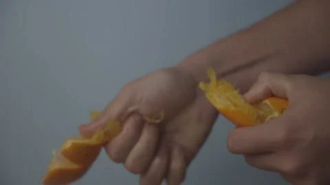 Pulling an Orange Apart with a Blue Background LOG Stock Footage 136992481
