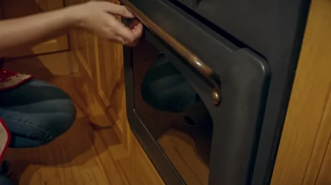 Pulling out the Christmas shaped cookie on protivene from the oven Видео 58078747