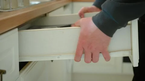 Pulling out kitchen drawer from cabinet for plumbing repair access, home Stock Footage 334040913