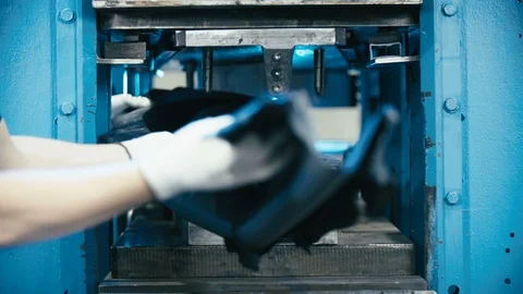 Pulling out a long rubber product from the machine press 4K Stock Footage 96371192