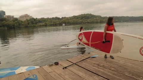 Pulling paddleboards out of river Stock Footage 145737609