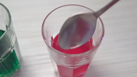 Pulling a painted pink chicken egg out of a glass of paint Stock Footage 153911215