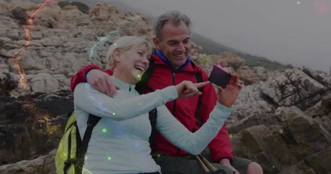 Pulling phone from pocket, hikers shooting selfie capturing adventure with AR Stock Footage 314173582