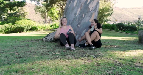 Pulling phone for selfie, Diverse female friends laughing, sharing water bottle Stock Footage 313955280