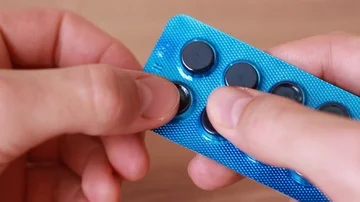 Pulling pills out from blue packing Видео 86056216