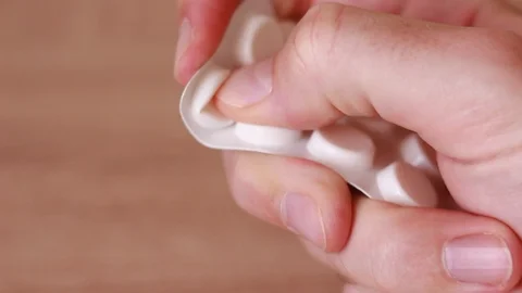 Pulling pills out from white packing Stock Footage 86056255
