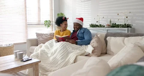 Pulling red book, African American father and daughter reading under blanket on Stock Footage 335927509