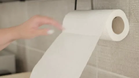 Pulling a sheet of white paper towel from a wall Stock Footage 344601499
