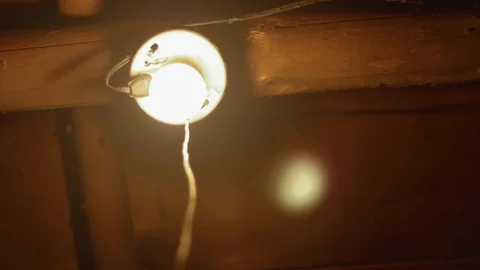 Pulling a single light cord to turn on and off a light in an old rustic cabin 库存影片 89499535