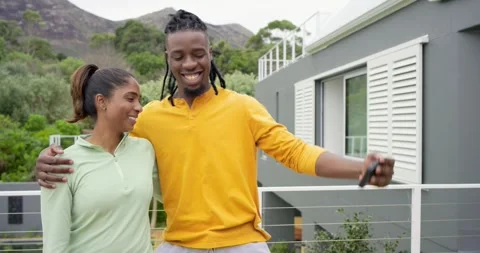 Pulling smartphone, African American man framing selfie with Indian woman on Stock Footage 317661562