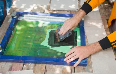 Pulling squeegee across silk screen Stock Photos