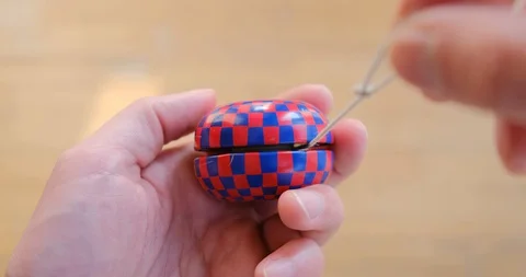 Pulling string while Yo-Yo spins in the hand - close up. Stock Footage 127608698