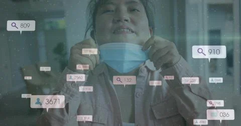 Pulling surgical mask down, Korean man wearing pink shirt in living room, with Stock Photos