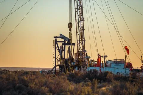 Pulling team fixing oil pump at sunset Stock Photos