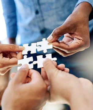 Pulling together to solve a problem. a work group connecting pieces of a puzzle. Foto stock
