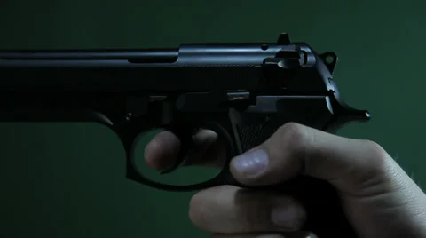 Pulling trigger and shoot on green Stock Footage 33941327