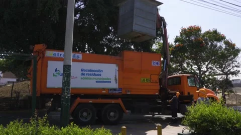 Pulling an underground garbage container with chains from a hydraulic truck Stock Footage 149910573