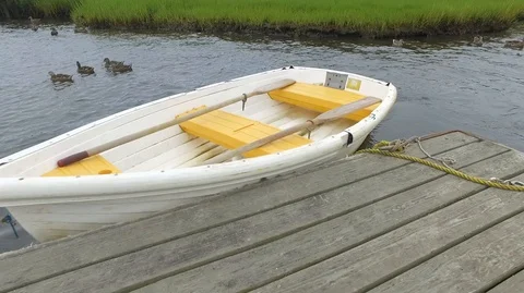 PULLING YELLOW AND WHITE DINGHY AT DOCK Stock Footage 104841729