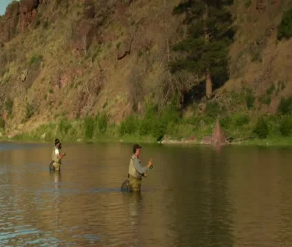Pullout shot of father and son flyfishing Stock Footage 21654311