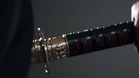 Pulls a katana from its sheath in a dark room Video stock 129834564