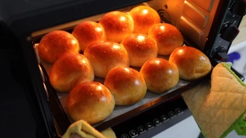 Pulls out of the oven tray with freshly baked bread buns Stock Footage 125965036