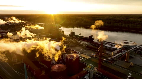 Pulp and paper mill emitting smoke at golden hour, aerial view Stock Footage 297054444