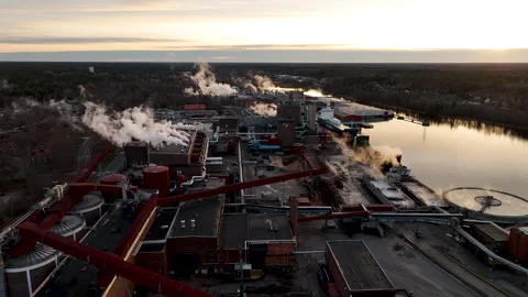 Pulp and paper mill releasing steam at sunset Stock Footage 297054592