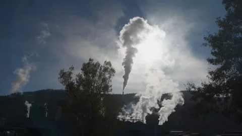 Pulp mill pollution exhausts across the  sun and clouds, 4k Video stock 164612052