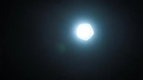 Pulsating flashlight beam shining directly into camera on black background. Stock Footage 315773802