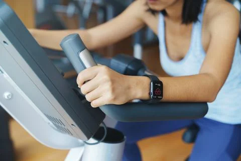 Pulse app display on smartwatch in the hands of a woman exercisi Stock Photos
