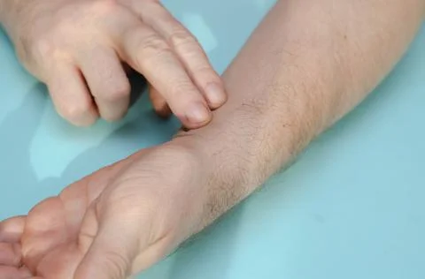 Pulse check. Middle-aged man with his finger on his wrist. Close-up. Inside t Stock Photos