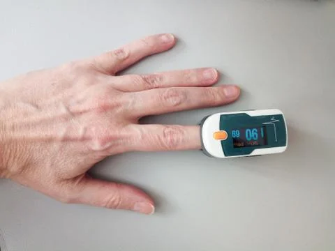 Pulse oximeter on a finger in a mature woman, measurement of oxygen level in  Stock Photos