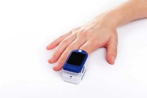 Pulse oximeter on a finger on white background. Stock Photos