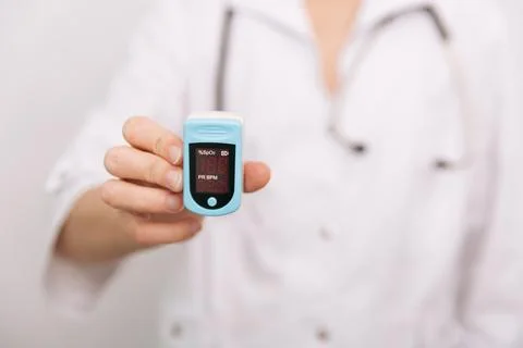 Pulse oximeter with hand of doctor isolated on white. Measuring oxygen Stock Photos