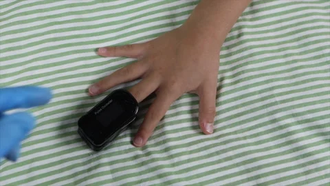 Pulse oximeter measure pulse rate, oxygen on finger of kid, close-up. Stock Footage 142015688
