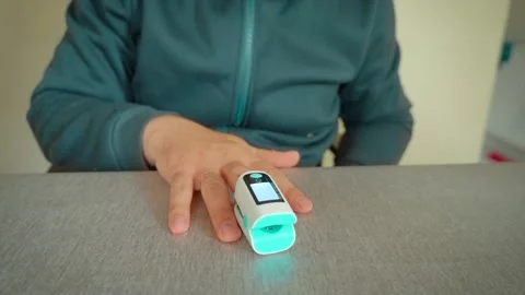 Pulse oximeter oxygen saturation measurement on finger at home. Adult man Stock-Footage 336717985