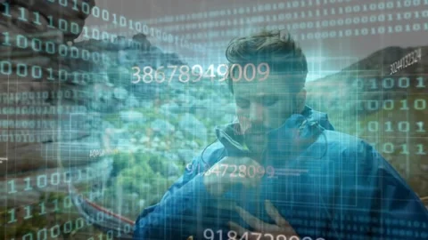 Pulsing binary code overlaying canyon hiker retrieving device and inspecting 動画素材 317739883