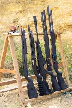 Pump-action and semi-automatic shotguns at the shooting range. Caliber 12. Co Stock Photos
