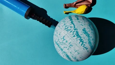 A pump for inflating festive balloons. the turquoise ball deflates the air Stock Footage 250965797