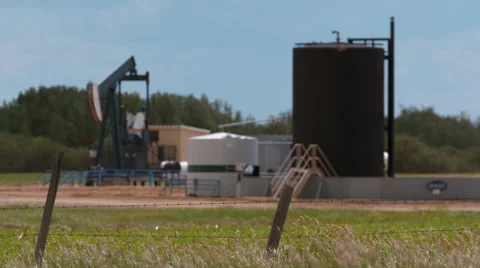 Pump jack and storage facility in the country side. Stock Footage 67614170