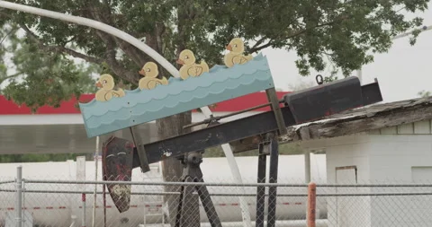 A pump jack fitted with board drawn with duck and water on it Stock Footage 149348529