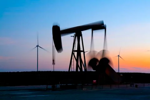Pump jack in motion on a wind farm in Ft. Davis, Texas Stock Photos