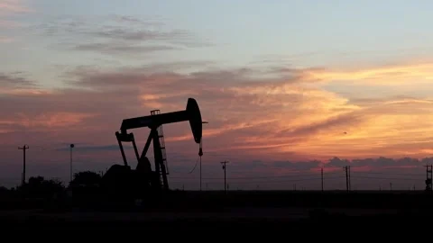 Pump Jack Pumping in Desert Field during Morning Sunrise with Dramatic Clouds Stock Footage 345704232
