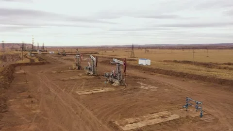 Pump jack in vast oil fields in Russia. Pipelines transporting oil from oil Stock Footage 170332049