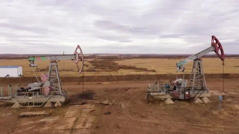 Pump jack in vast oil fields in Russia. Pipelines transporting oil from oil Stock Footage 171918256