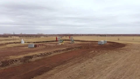 Pump jack in vast oil fields in Russia. Pipelines transporting oil from oil Stock Footage 171918399