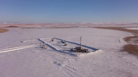 Pump jack in vast oil fields in winter. Pipelines transporting oil from oil Stock Footage 171918567